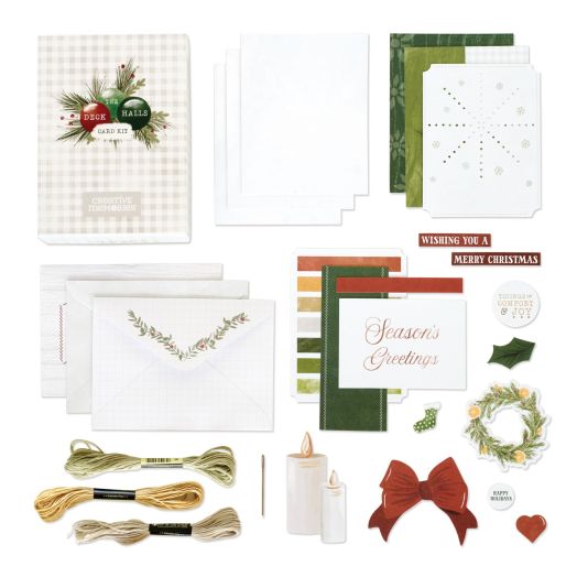 Deck the Halls Christmas card kit on white background. Includes a gift box, envelopes, white card bases, papers to adhere to the card bases, embellishments with icons like wreathes and candles, titles like Wishing you a Merry Christmas and embroidery thre
